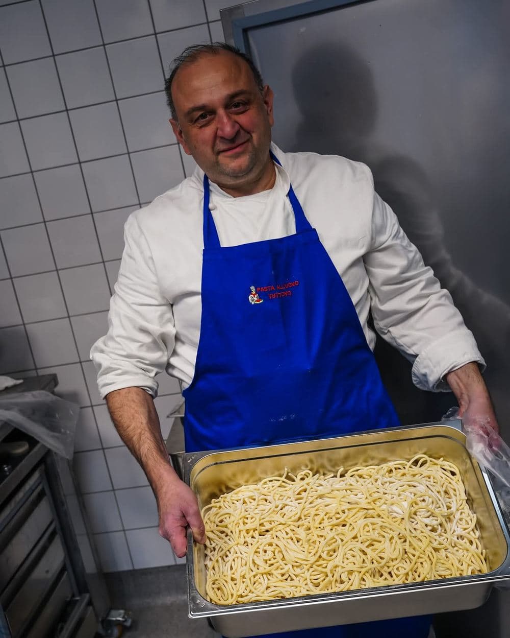 Kock med en bricka färsk spaghetti